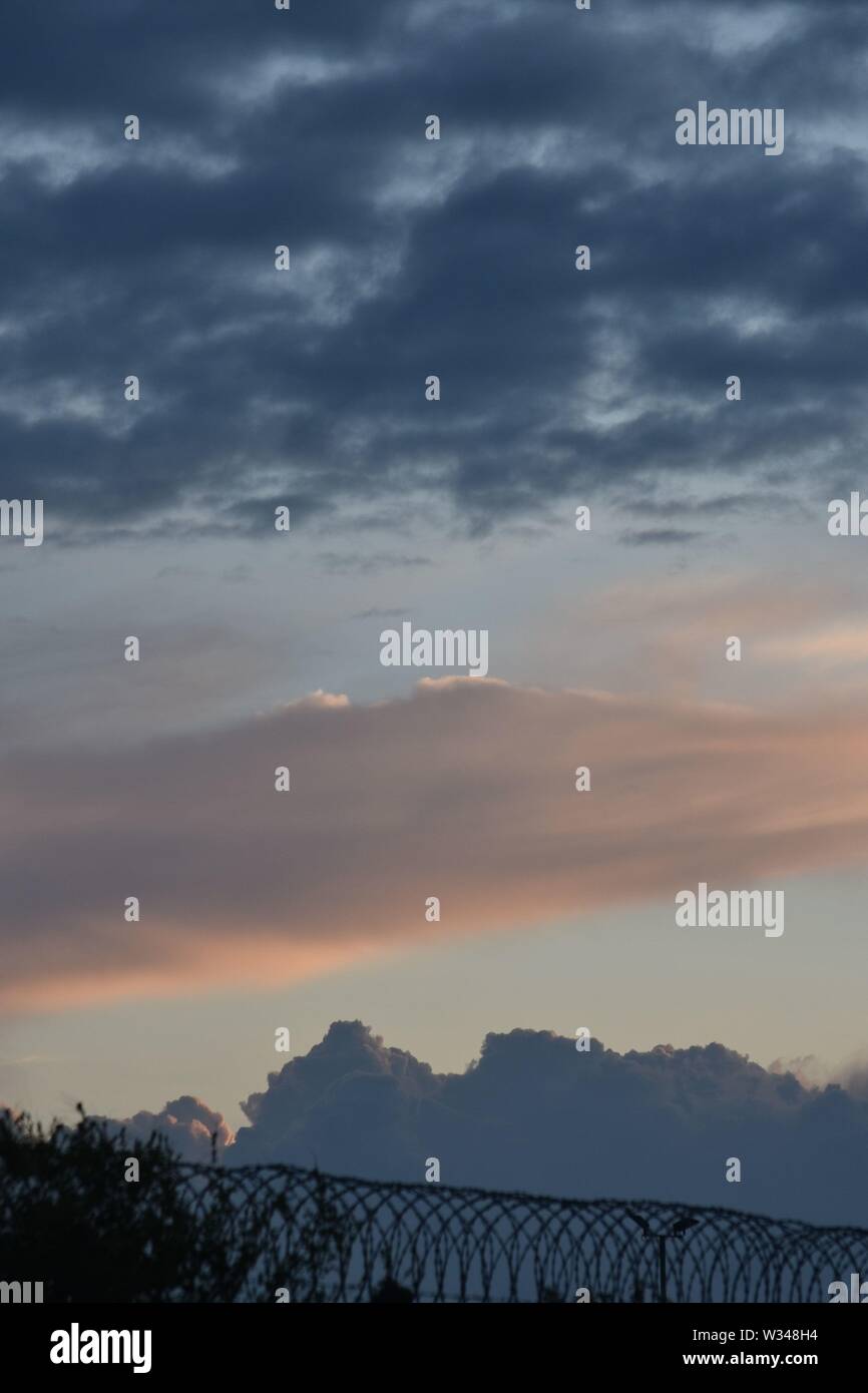 Sonnenuntergang mit dunklen Wolken und sanften Pastelltönen in das Licht der untergehenden Sonne Stockfoto