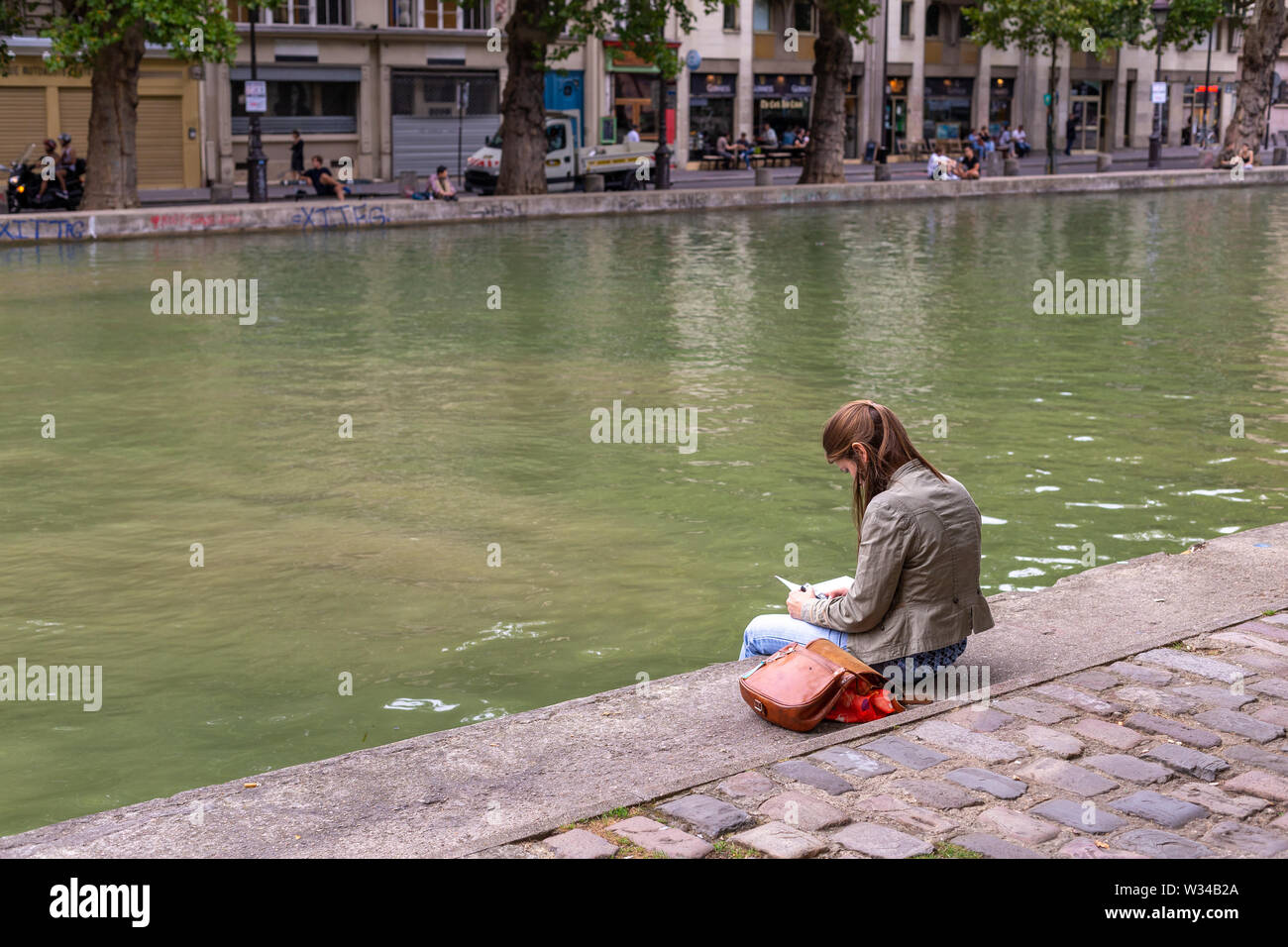 Paris, Frankreich, August 04, 2014: Menschen am Nachmittag genießen, entspannen, lesen und sprechen, am Rande des Canal Saint Martin Stockfoto