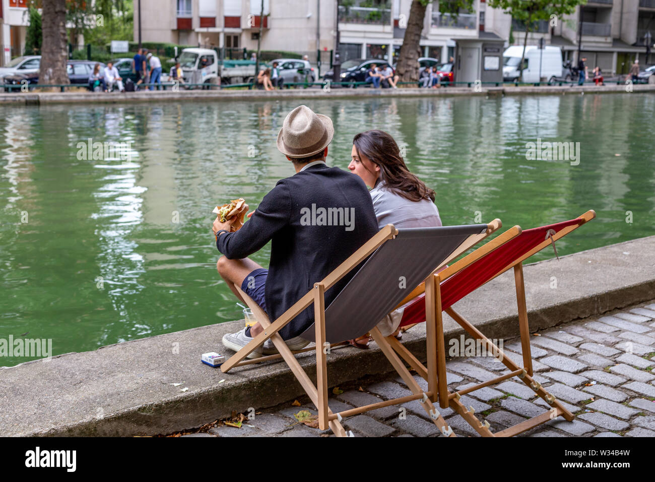 Paris, Frankreich, August 04, 2014: Menschen am Nachmittag genießen, entspannen, lesen und sprechen, am Rande des Canal Saint Martin Stockfoto
