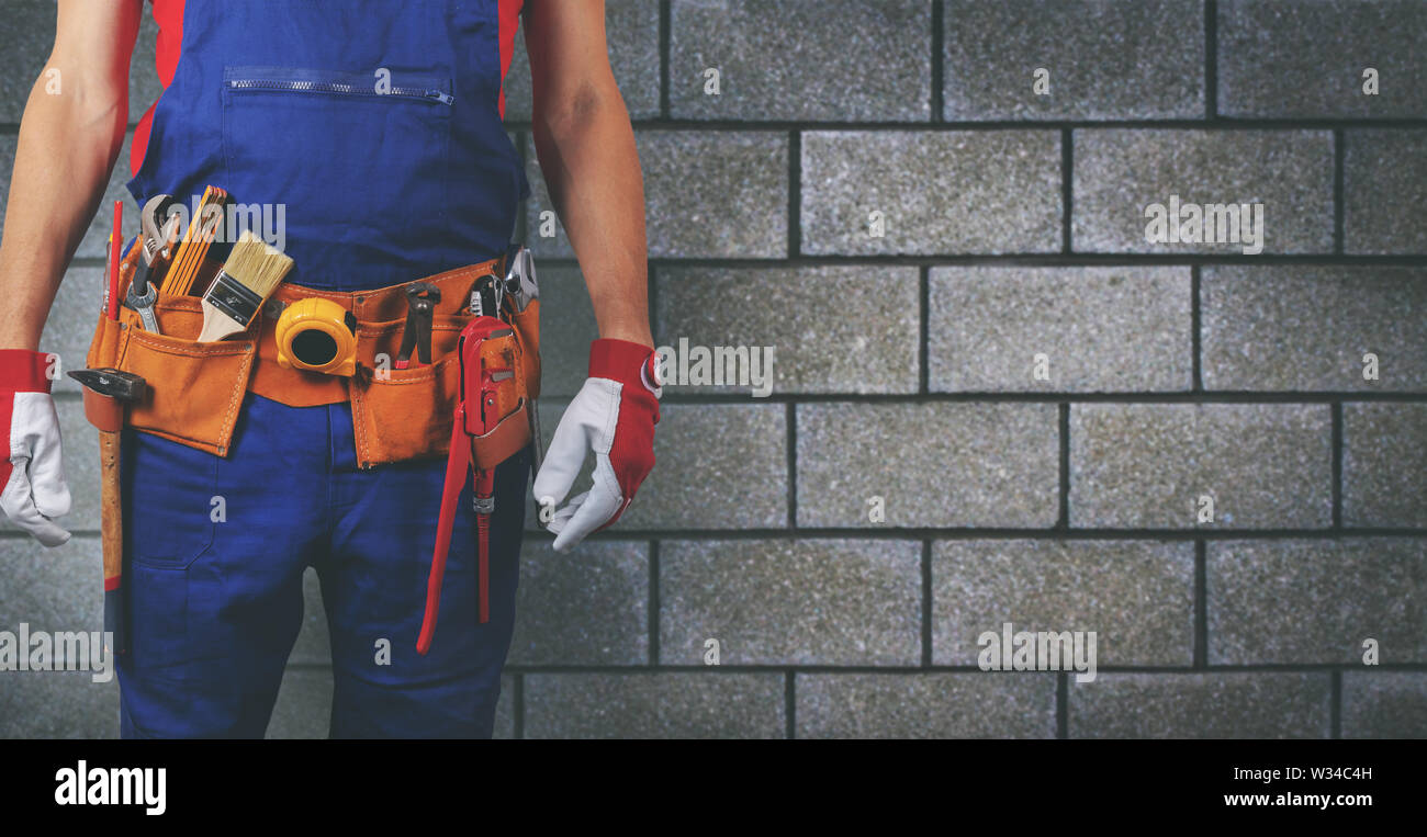 Bauarbeiter mit Werkzeug Gürtel auf Block wand hintergrund Kopie Raum Stockfoto