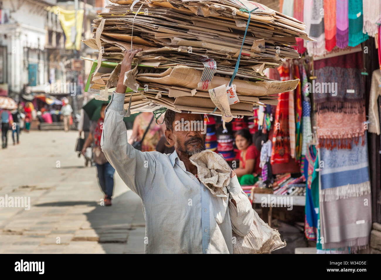Mann, der einen Haufen von Karton auf dem Kopf in Kathmandu Stockfoto