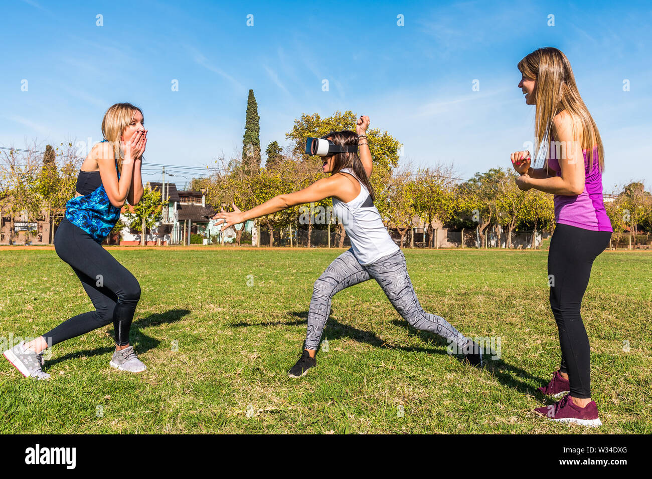 Drei kaukasischen Frauen im Park zwei Blondinen und eine Brünette mit virtueller Realität Maske Stockfoto