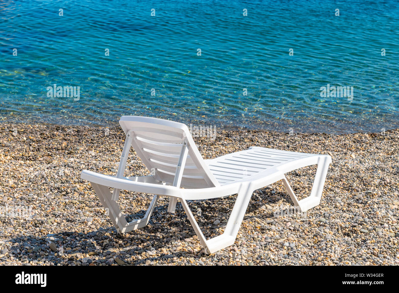 Leere Kunststoff weiß Chaise Lounge auf dem Hintergrund des Meeres Stockfoto