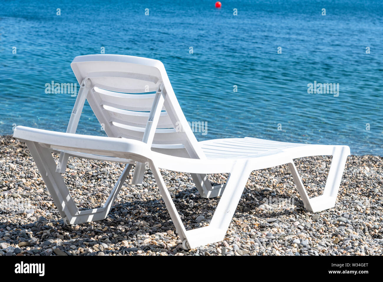 Leere Kunststoff weiß Chaise Lounge auf dem Hintergrund des Meeres Stockfoto