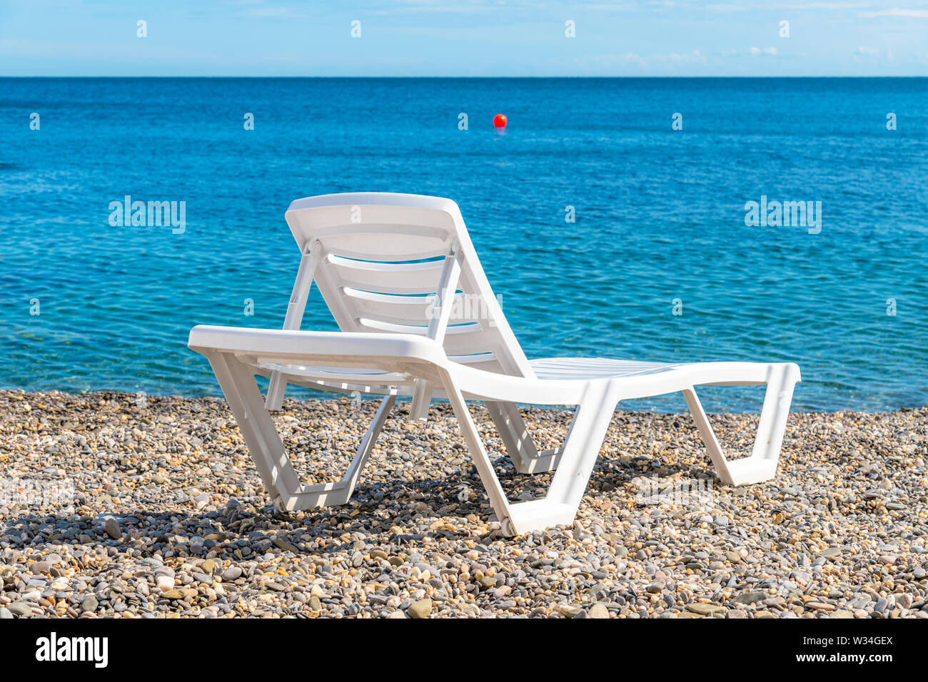 Leere Kunststoff weiß Chaise Lounge auf dem Hintergrund des Meeres Stockfoto
