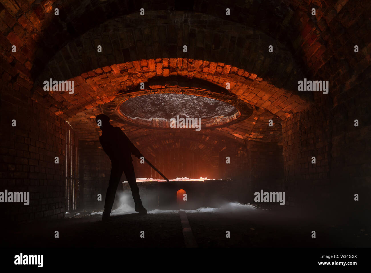 Silhouette von Eisen Arbeiter schürt einen Ofen im Blaenavon Iron Works, in Ebbw Vale, Wales Stockfoto