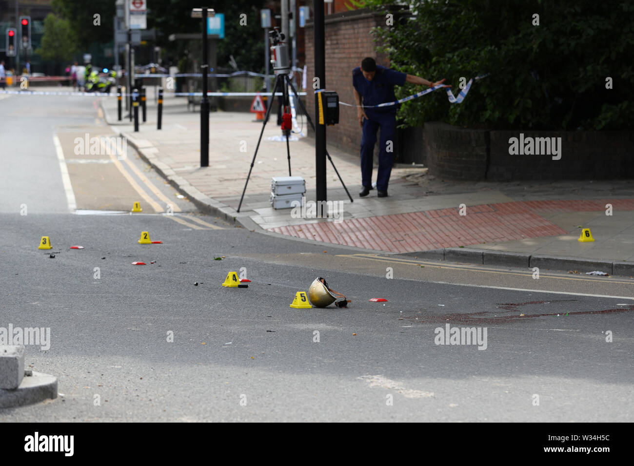 Die ERNEUTE ÜBERTRAGUNG MIT ZUSÄTZLICHEN PIXELATION AUFGRUND DER GRAFISCHEN INHALTE. Ein Helm auf dem Boden liegt an einer Szene in Battersea, süd-west London, wo die Frau, nach der von den Lastkraftwagen getroffen werden beim Reiten eines scooter gestorben ist. Stockfoto