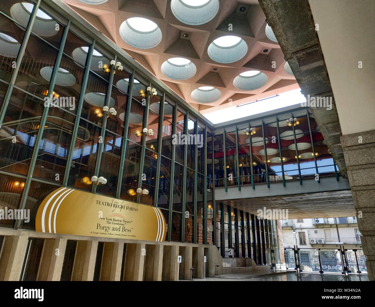 Turin, Piemont, Italien. Juni 2019. Die moderne Eingang des Teatro Regio di Torino. Eine große goldene Zeichen zeigt den Titel der Arbeit programmiert werden Stockfoto