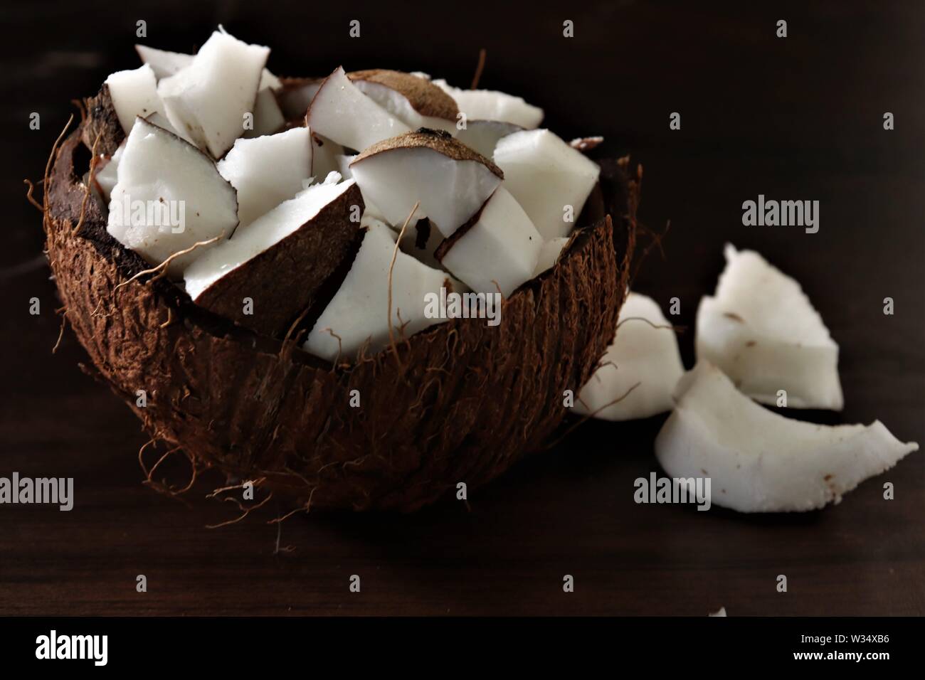 In der Nähe des raw coconut Fleisch/Stück in der Coconut Shell auf einem Holztisch Stockfoto