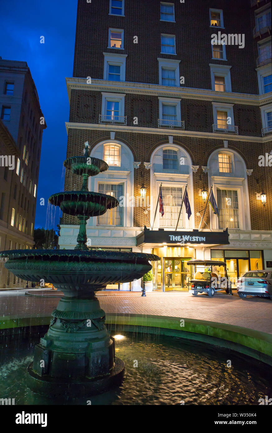 GREENVILLE, SC (USA) - Juli 5, 2019: Ein Nach-düstere Sicht auf die Downtown Hotel Westin mit einem Brunnen im Vordergrund. Stockfoto