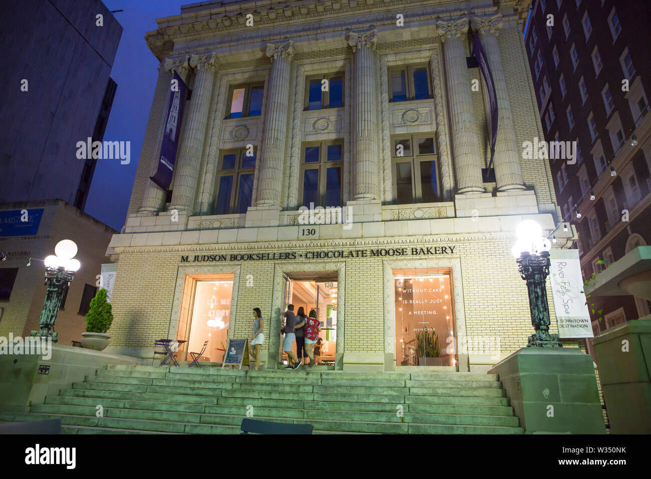 GREENVILLE, SC (USA) - Juli 5, 2019: Shopper besuchen eine Bäckerei und Buchhandlung in einem renovierten Gebäude in einer warmen Sommernacht in der Innenstadt. Stockfoto