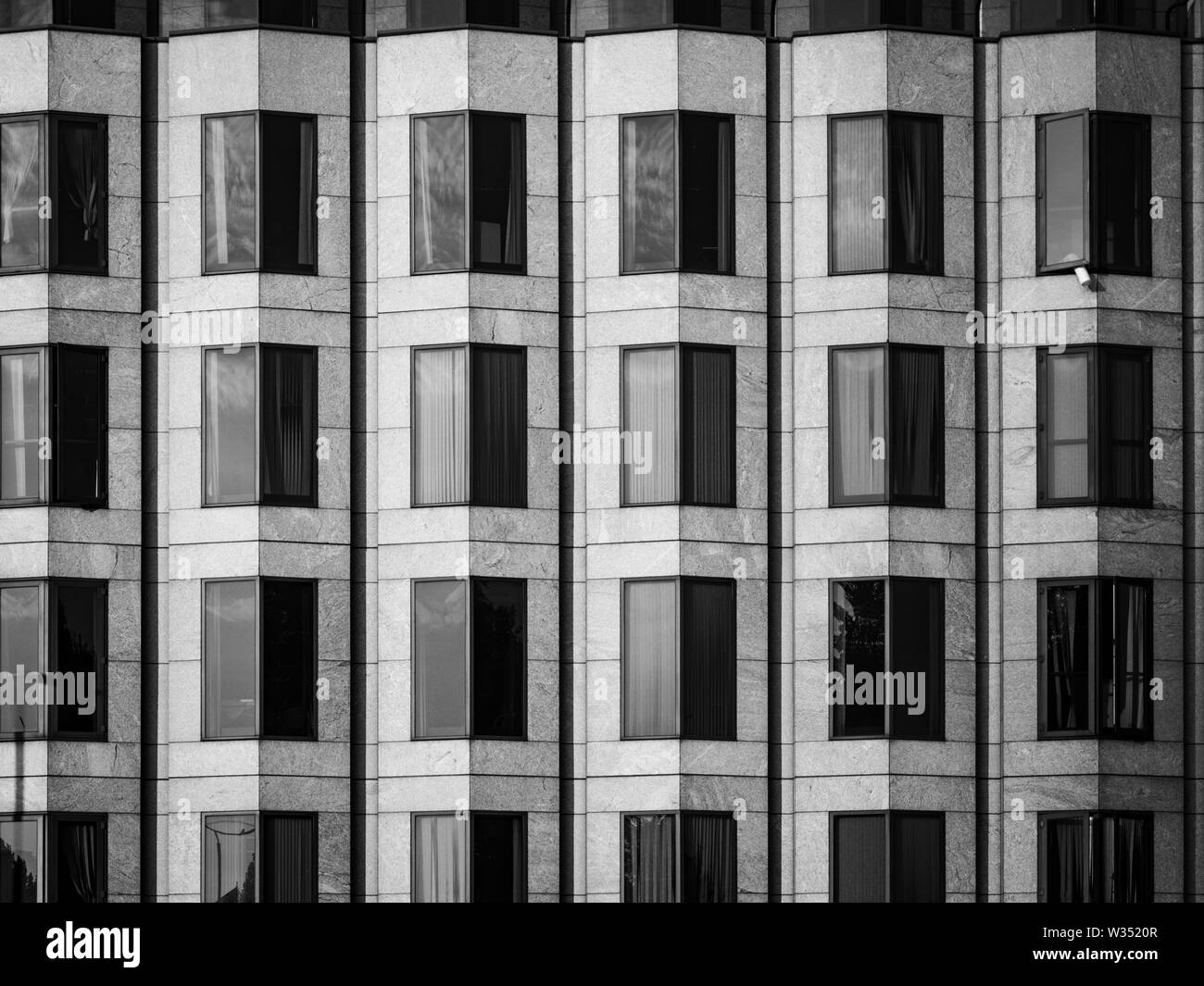 Eine schwarze und weiße, abstraktes Bild von eckigen Fenster auf der Vorderseite ein modernes Gebäude. Stockfoto