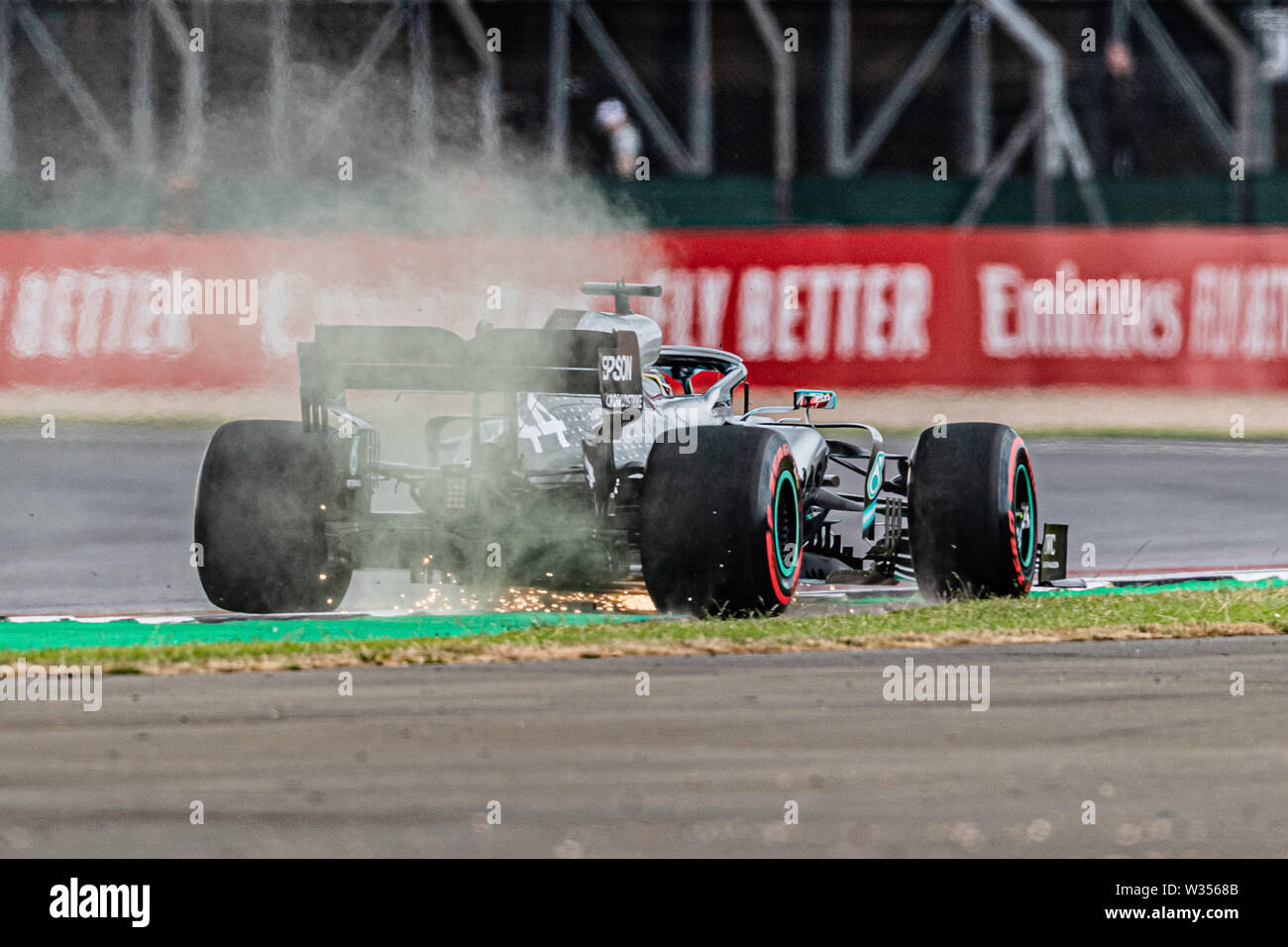 TOWCESTER, VEREINIGTES KÖNIGREICH. 12 Jul, 2019. Feuer funkeln auf Lewis Hamilton Mercedes in der Praxis 1 gezeigt während Formel 1 Rolex Grand Prix von Großbritannien 2019 in Silverstone am Freitag, Juli 12, 2019 in TOWCESTER, ENGLAND. Credit: Taka G Wu/Alamy leben Nachrichten Stockfoto