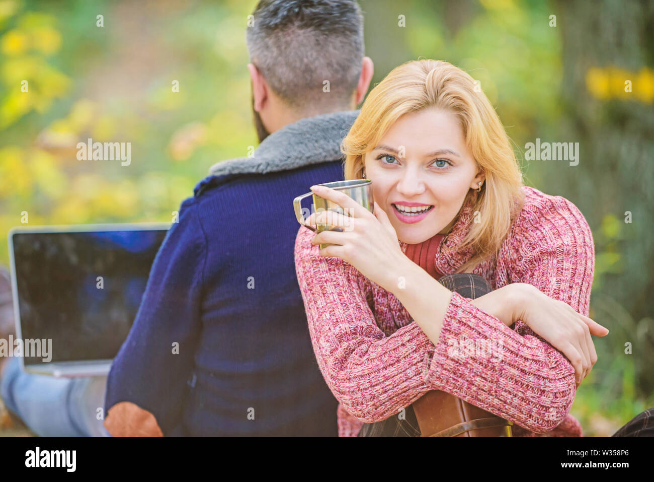 Sagen Sie Nein zu Office Routine. Familie Picknick. Beziehung. glückliches Mädchen trinken heißen Kaffee oder Wein. Mann Sitzen mit zurück. Frühling Stimmung. Camping und Wandern. verliebtes Paar im Herbst Wald mit Computer entspannen. Stockfoto
