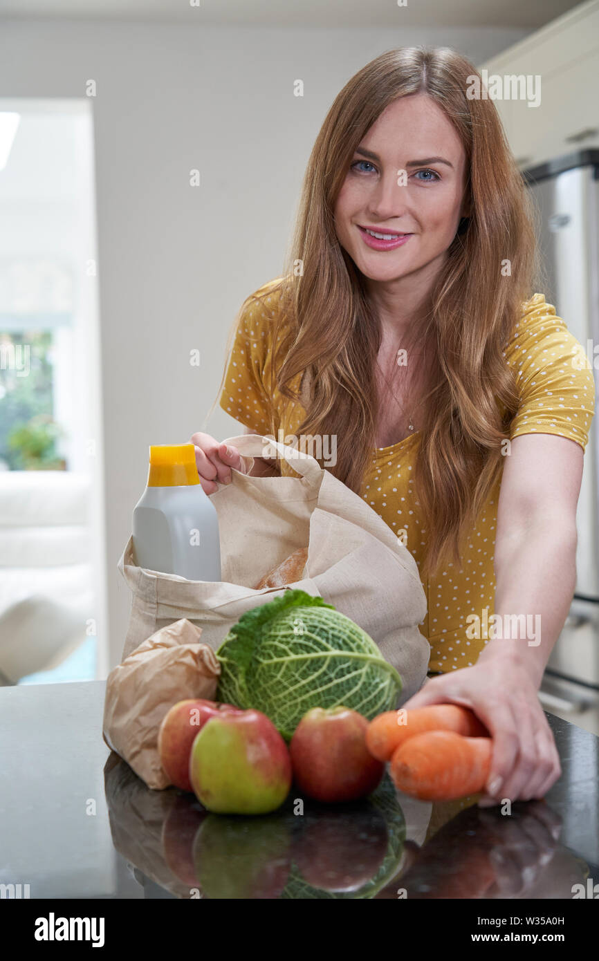 Portrait von Frau Heimweg von Shopping Trip Auspacken Kunststoff Kostenlose Einkaufstaschen Stockfoto