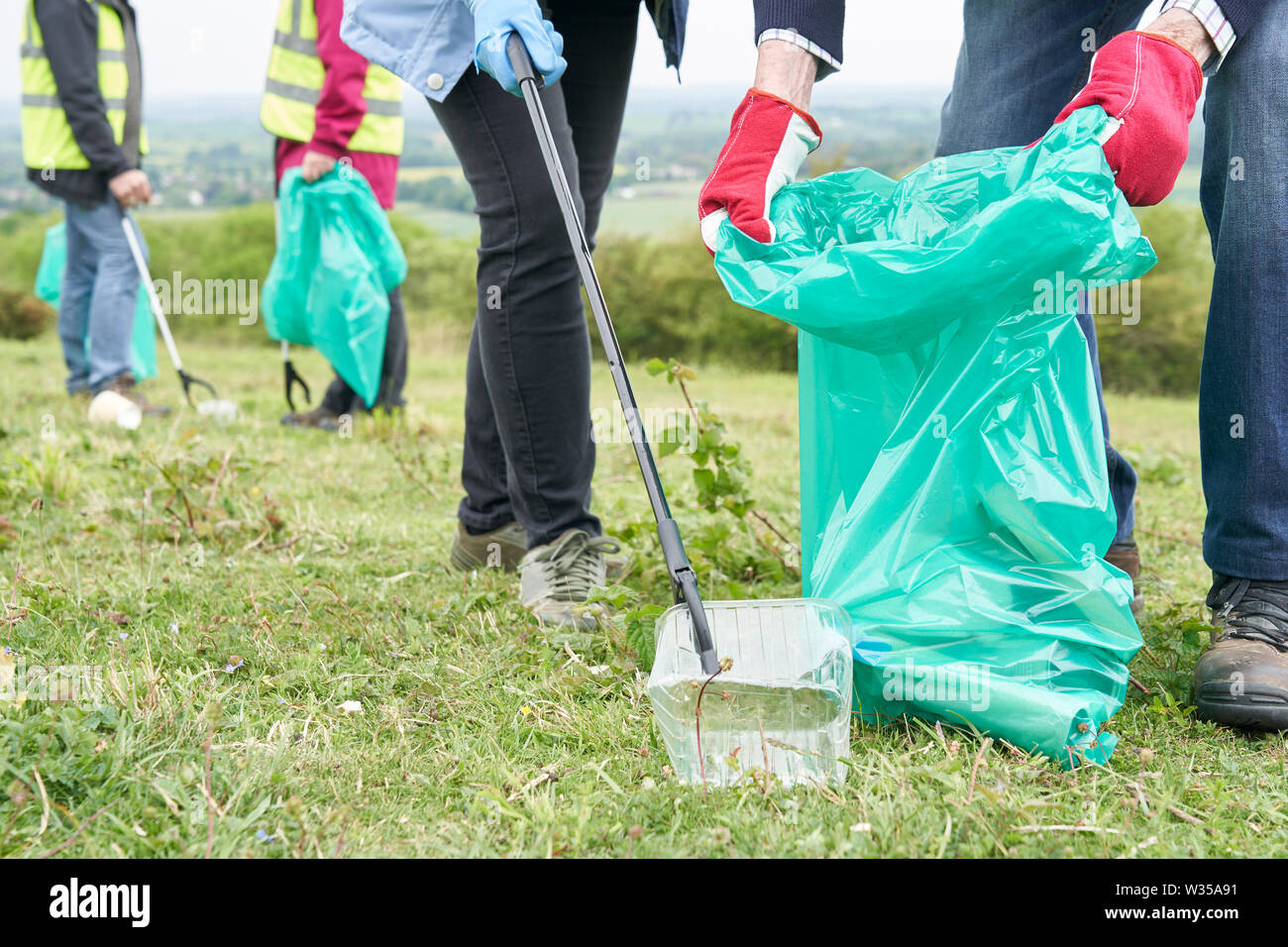 In der Nähe der Gruppe hilfreiche Senioren sammeln Müll in der Landschaft Stockfoto