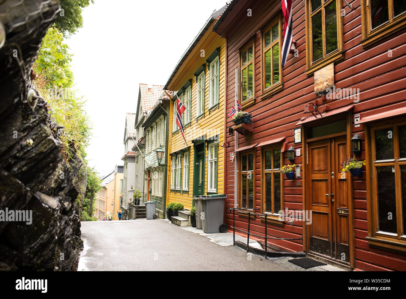 Traditionelle bunt bemalte Holzhäuser fliegen norwegische Flaggen in der Altstadt von Bergen, Norwegen. Stockfoto