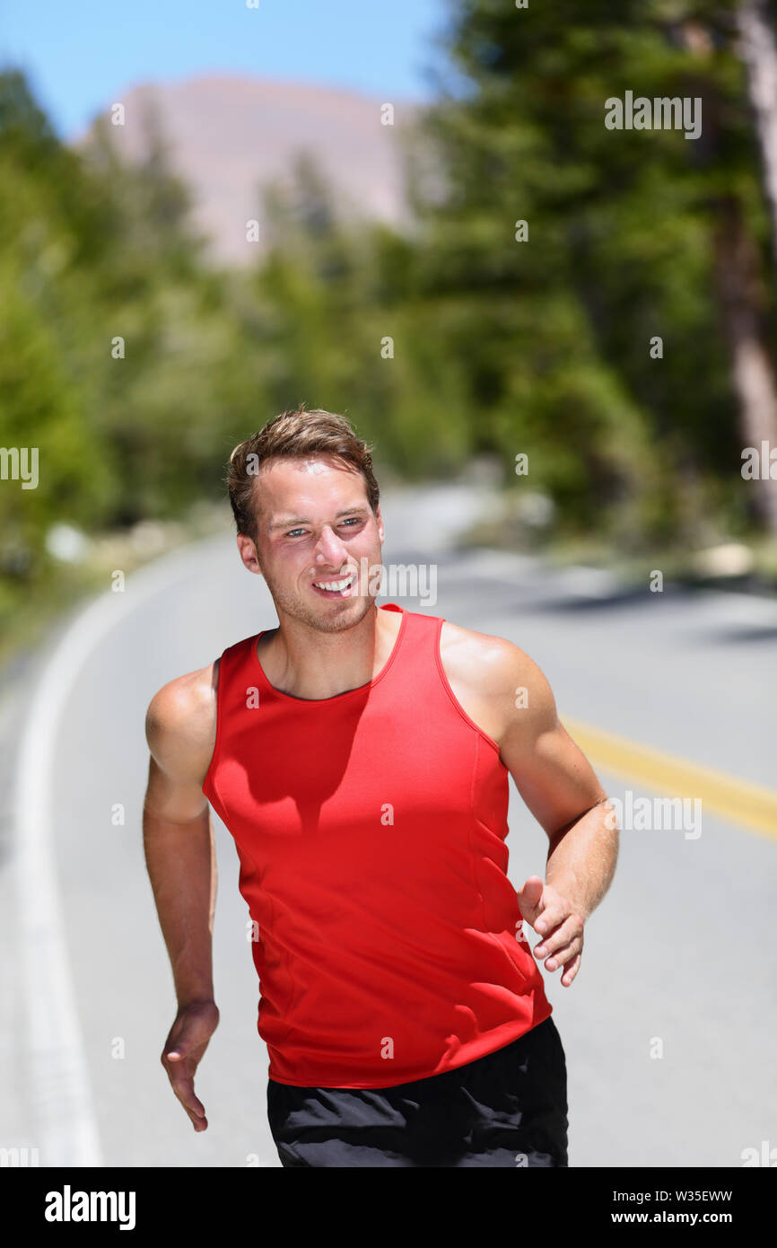 Laufende Läufer training cardio auf Forststraße. Männliche Athlet, Joggen in der Natur an einem Sommertag. Kaukasische Erwachsenen. Stockfoto