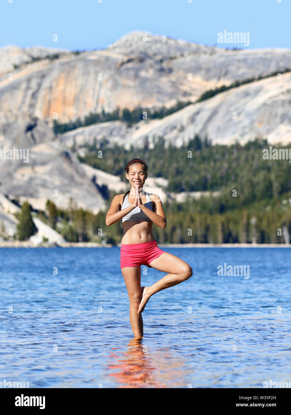 Yoga meditation Frau Meditation in der freien Natur relaxen im Yoga Haltung, Baum, vrksasana. Entspannte ruhige asiatische Frau genießen Sommer in einem See in Yosemite National Park, Kalifornien, USA. Stockfoto