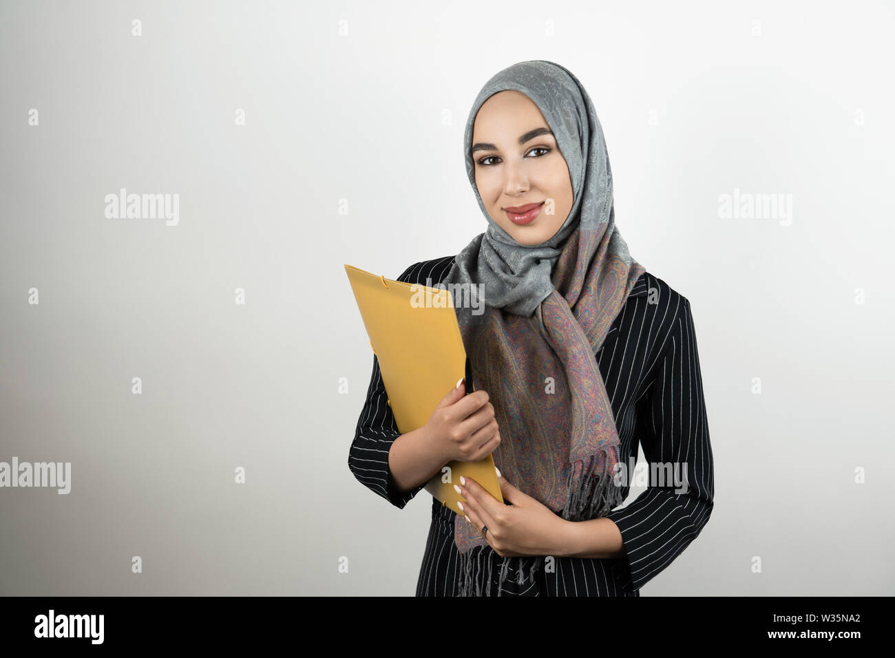Junge schöne Muslimischen business Frau mit Turban hijab Kopftuch Ordner mit Dokumenten isoliert weißer Hintergrund Stockfoto
