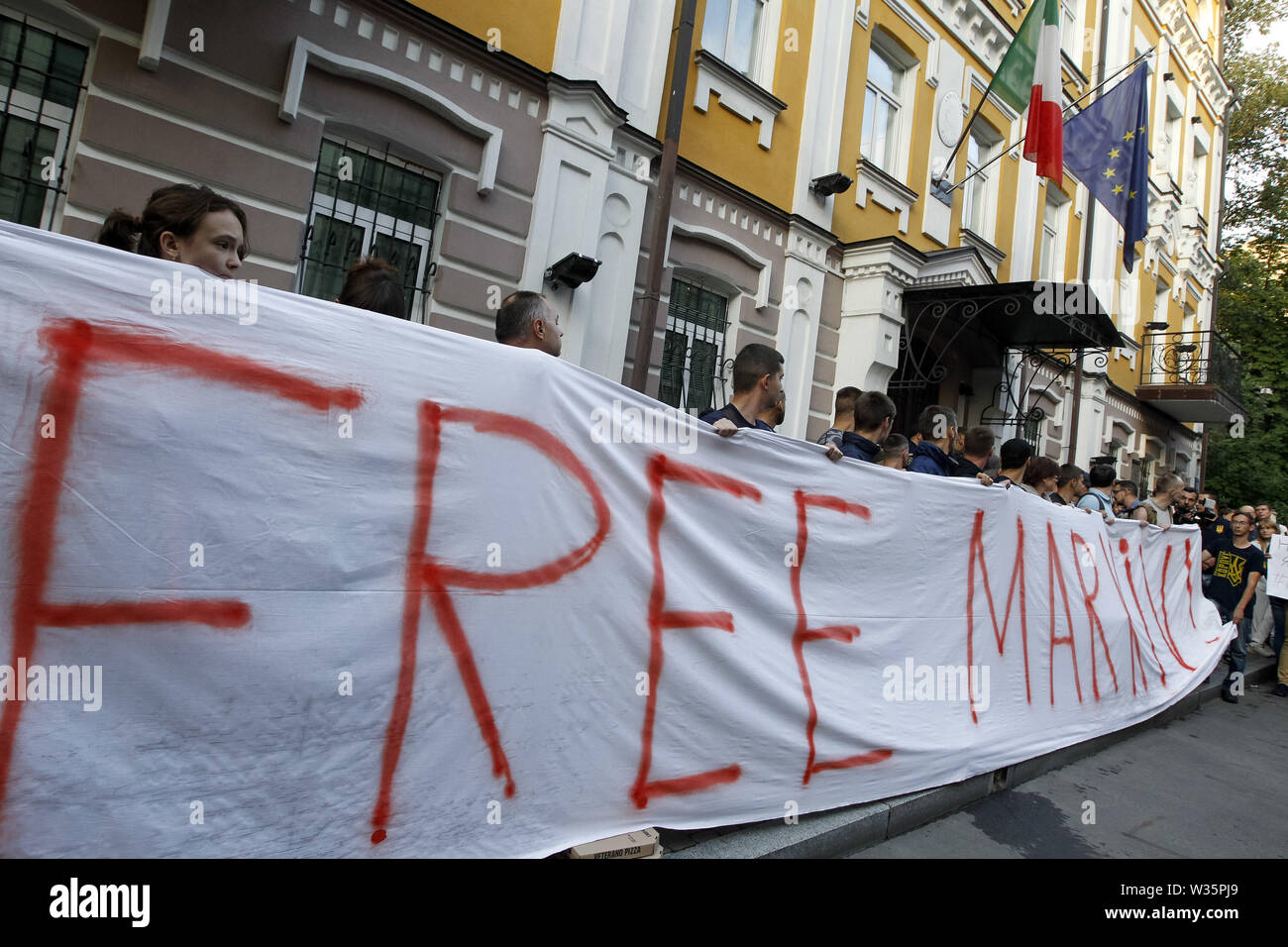 Kiew, Ukraine. 12. Juli, 2019. Ukrainische Aktivisten halten ein Banner lesen 'Frei' Markiv anspruchsvolle Version von ukrainischen Soldaten Vitaliy Markiv, vor die Botschaft von Italien in Kiew, Ukraine, am 12. Juli 2019. Ein italienisches Gericht am 12. Juli 2019 verurteilte einen ukrainischen ehemaligen National Guard commander Vitaliy Markiv auf 24 Jahre im Gefängnis für den Mord an einer Fotografin Andrea Rocchelli und seine Übersetzerin in den frühen Tagen des Konflikts im Osten der Ukraine. Ukrainische Soldaten Vitaly Markiv war im Prozess um die Tötung von Italienischen Fotografin Andrea Rocchelli und seine russische assistant Andre Stockfoto