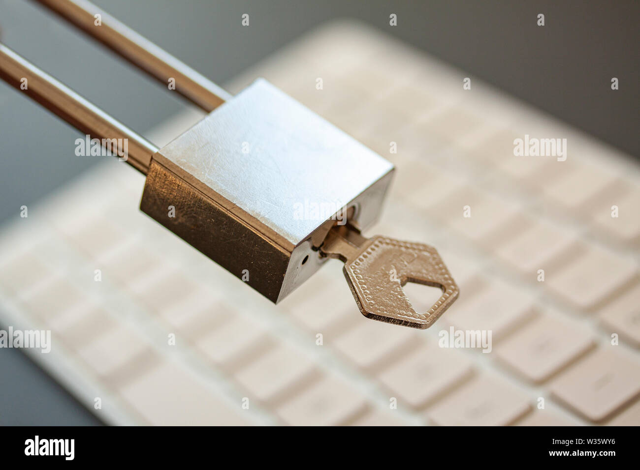 Rostfreier Vorhängeschloss mit Schlüssel vor der PC-Tastatur. PC-Netzwerk-Sicherheit, Datensicherheit und Virenschutz Konzept. - Bild Stockfoto