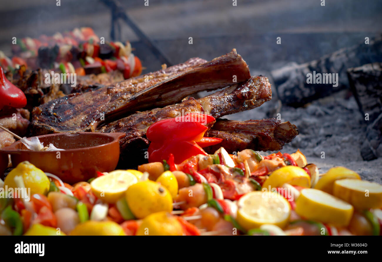 Traditionelle Argentinischer Grill. Große stück fleisch und gemüse Spieße auf dem Grill. Stockfoto