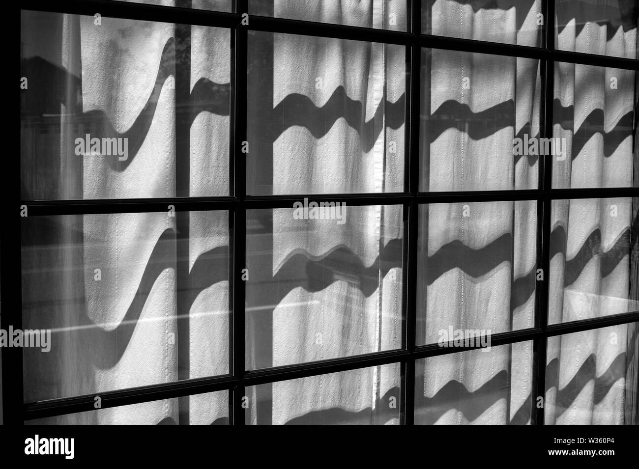 Fenster mit Vorhängen, Reflexionen und Holzrahmen. Stockfoto