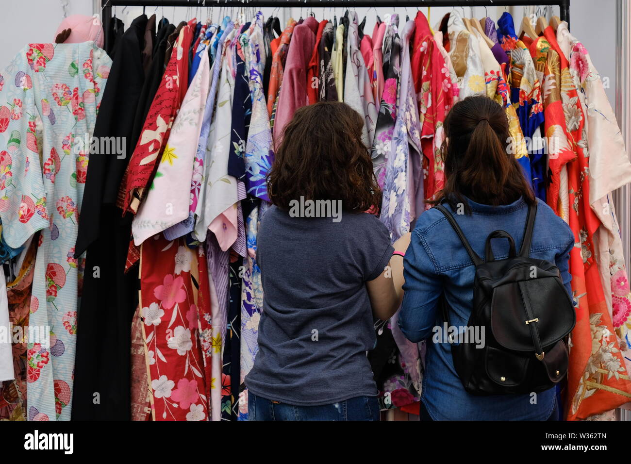 Zwei junge Frauen, die eine Kimonos-Schiene in Hyperjapan durchfahren. Stockfoto