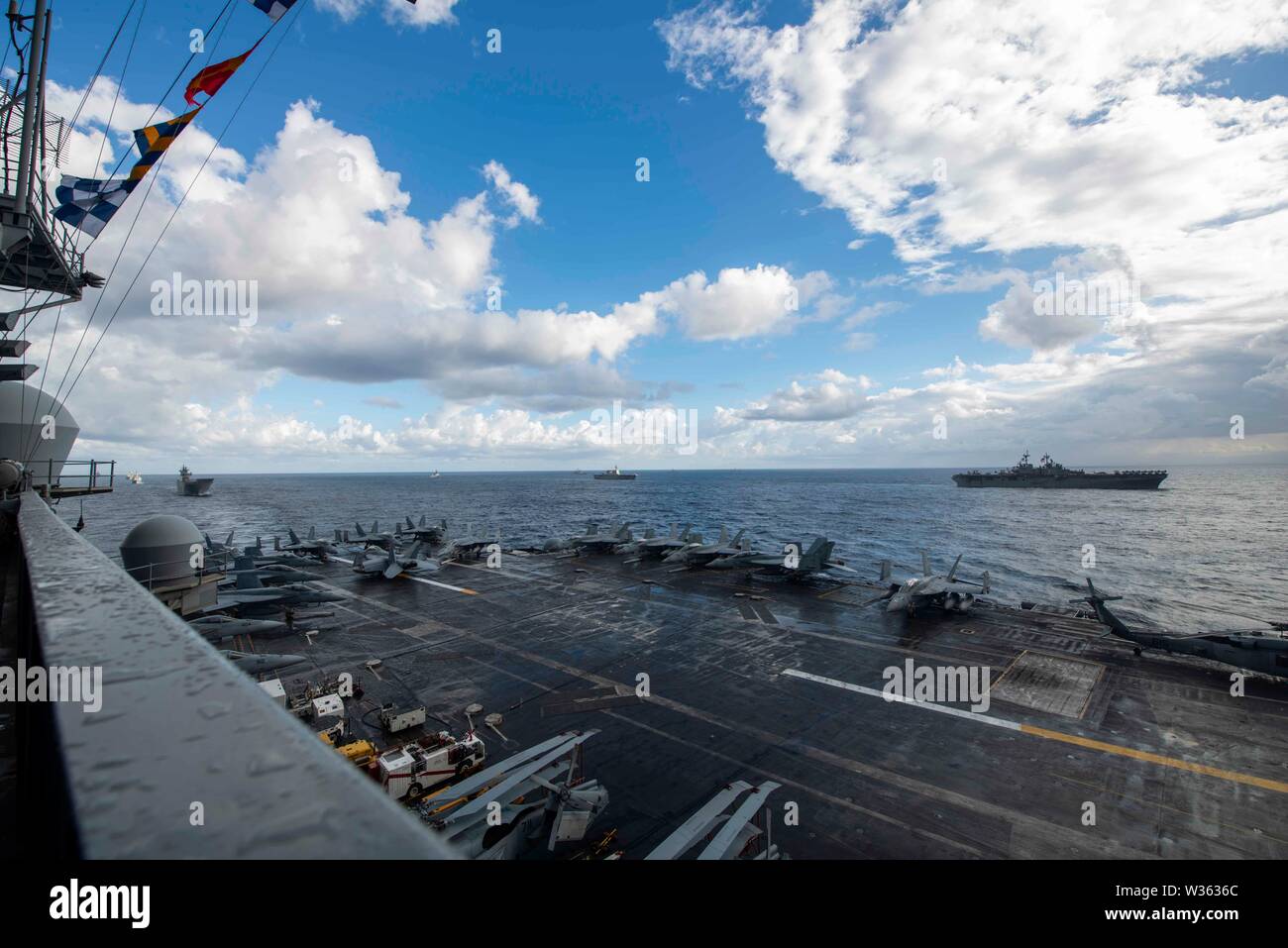 190711-N-PL 543-1007 CORAL SEA (11. Juli 2019) Die Marine vorwärts - bereitgestellt Flugzeugträger USS Ronald Reagan (CVN 76) Segeln neben, von rechts nach links, von der US-Marine Amphibious Assault ship USS Wasp (LL 1), die Japan Maritime Verteidigung-kraft Hubschrauber Zerstörer JS Ise (DDH182), und der Royal Australian Navy landing Helicopter dock HMAS Canberra (L02) während der Talisman Sabre 2019. Talisman Sabre 2019 zeigt die Nähe des australischen und US-amerikanischen Allianz und die Stärke der militärischen Beziehung. Es ist die achte Iteration dieser Übung. (U.S. Marine Foto von Stockfoto