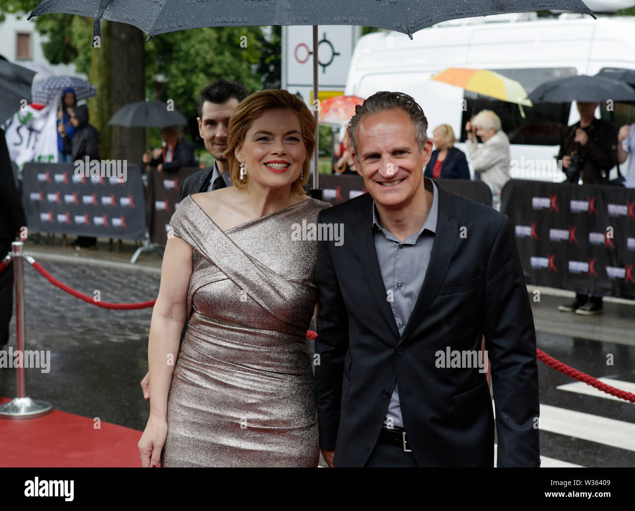 Worms, Deutschland. 12. Juli 2019. Julia Klöckner, das Bundesministerium für Ernährung, Landwirtschaft und Verbraucherschutz, und ihr Mann Ralph Grieser (links) bei der Premiere der "Nibelungen-Festspiele' ankommen. Schauspieler, Politiker und andere VIPs nahmen an der Eröffnung der Nibelungen-festspiele Nibelungen-Festspiele (2019) in Worms. Das Spiel in der 18. Saison des Festivals ist "Uberwaltigung' (Überwinden) zum Thema Thomas Melle, und von Lilja Rupprecht geleitet. Es erzählt von der ursprünglichen Lied der Nibelungen, beginnend am Ende und versucht, die Geschichte zu einem besseren, weniger de zu schreiben Stockfoto