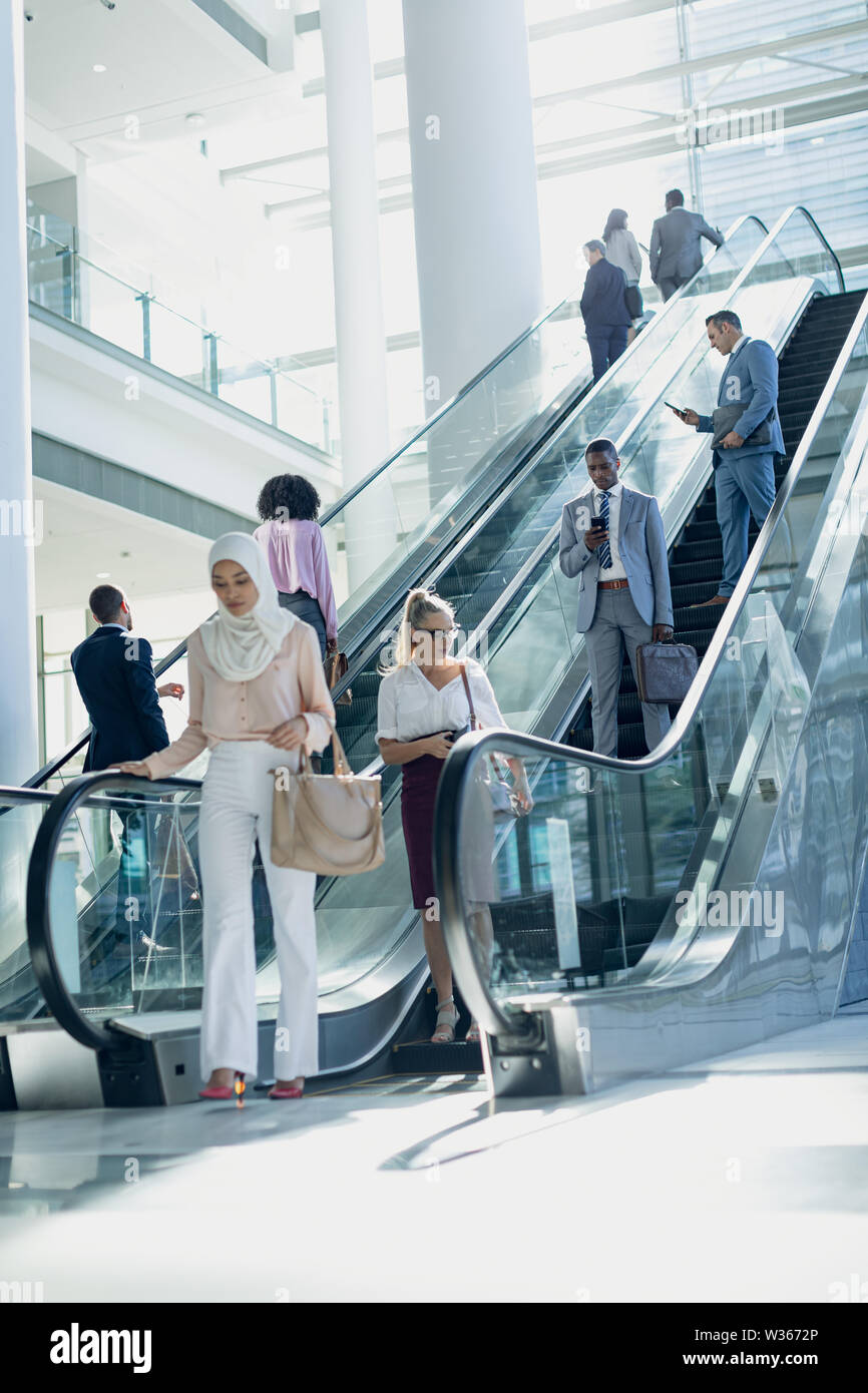 Diverse Geschäftsleute mit Fahrtreppen in modernen Büro Stockfoto