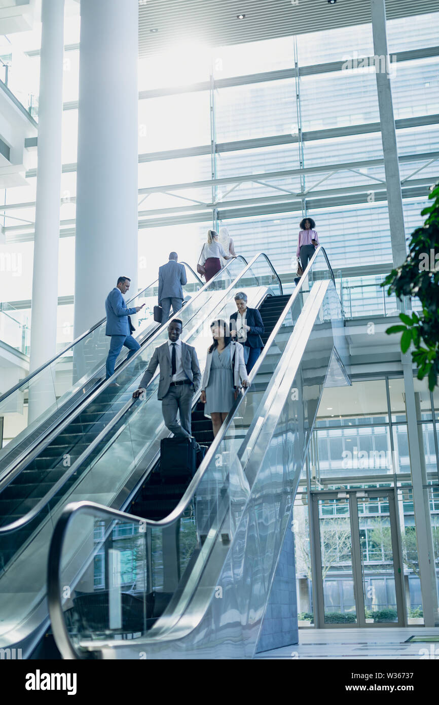 Diverse Geschäftsleute mit Fahrtreppen in modernen Büro Stockfoto