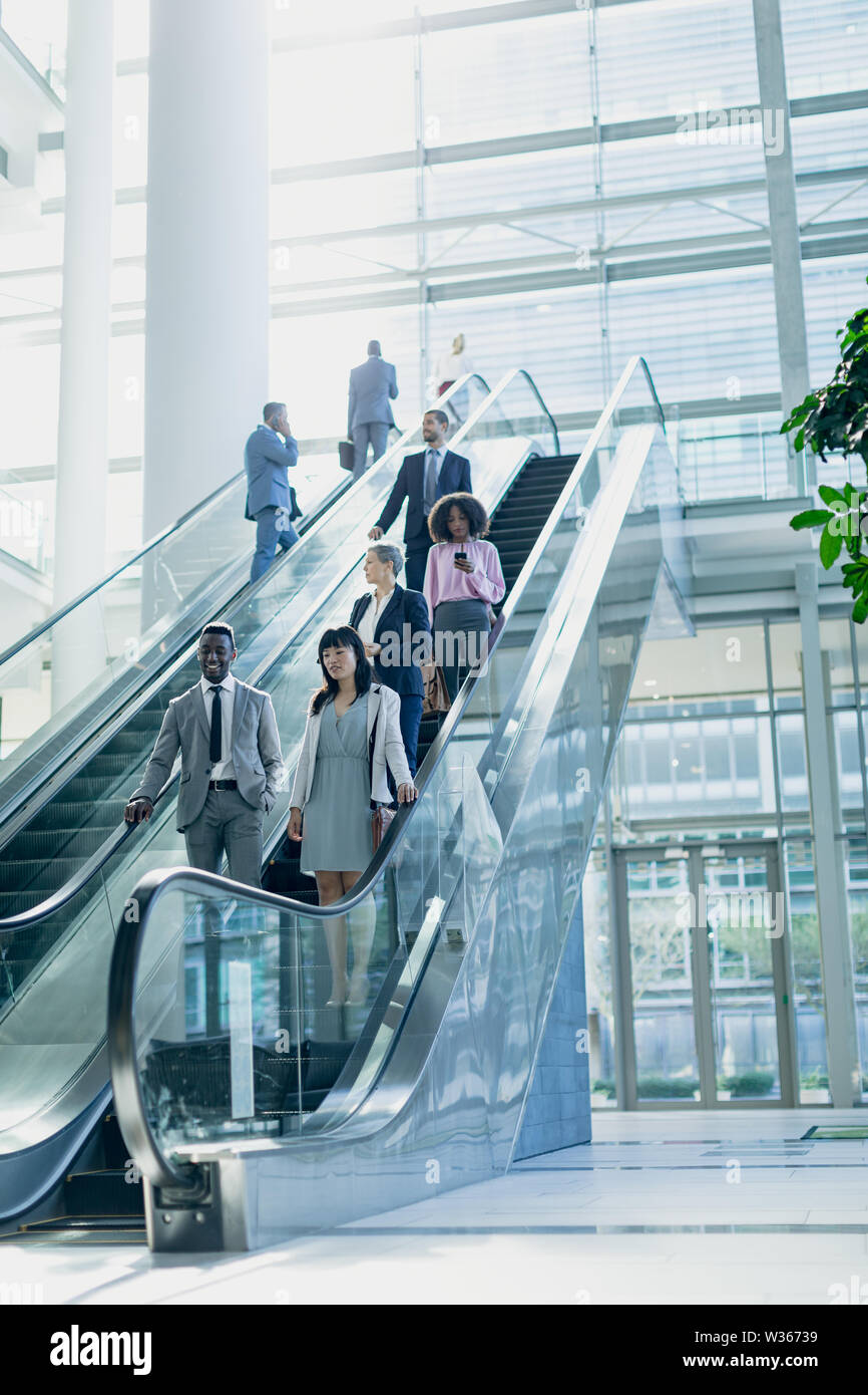 Diverse Geschäftsleute mit Fahrtreppen in modernen Büro Stockfoto