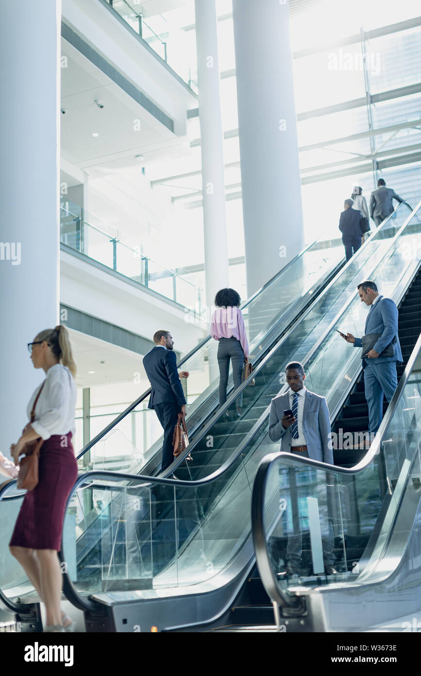Diverse Geschäftsleute mit Fahrtreppen in modernen Büro Stockfoto