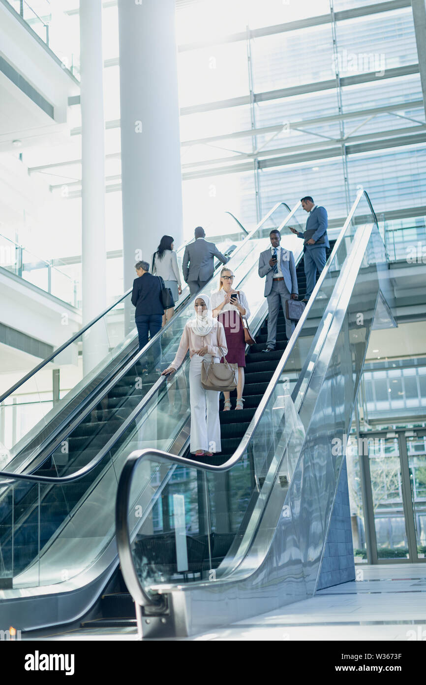 Diverse Geschäftsleute mit Fahrtreppen in modernen Büro Stockfoto