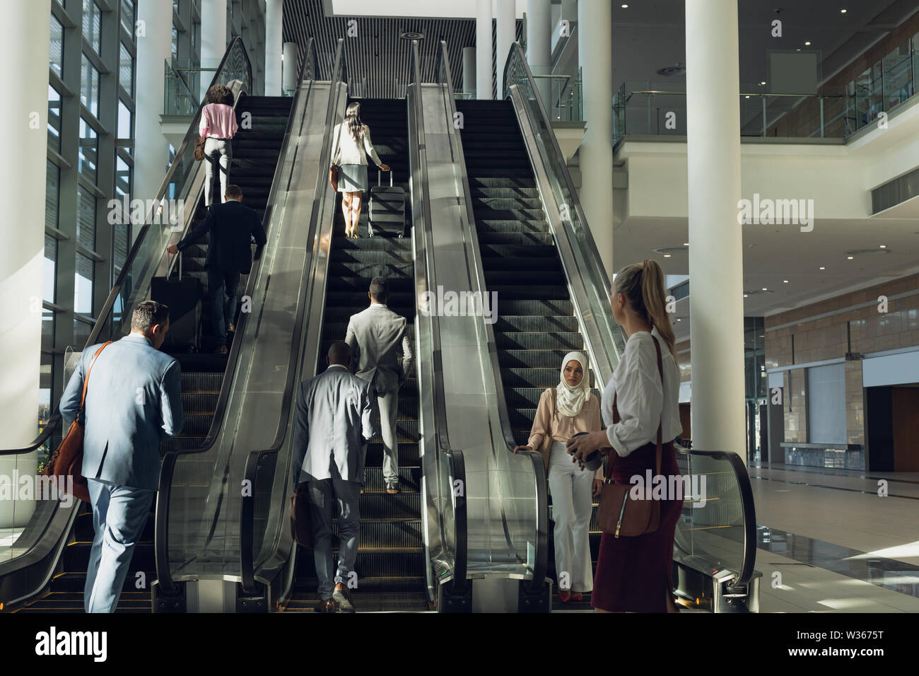 Geschäftsleute mit Fahrtreppen in modernen Büro Stockfoto