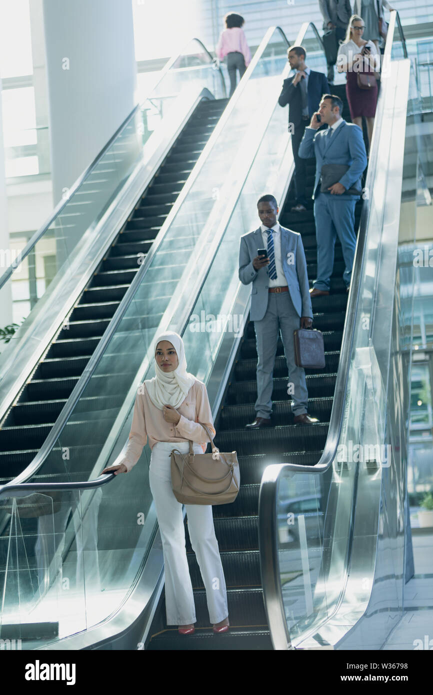 Diverse Geschäftsleute mit Fahrtreppen in modernen Büro Stockfoto