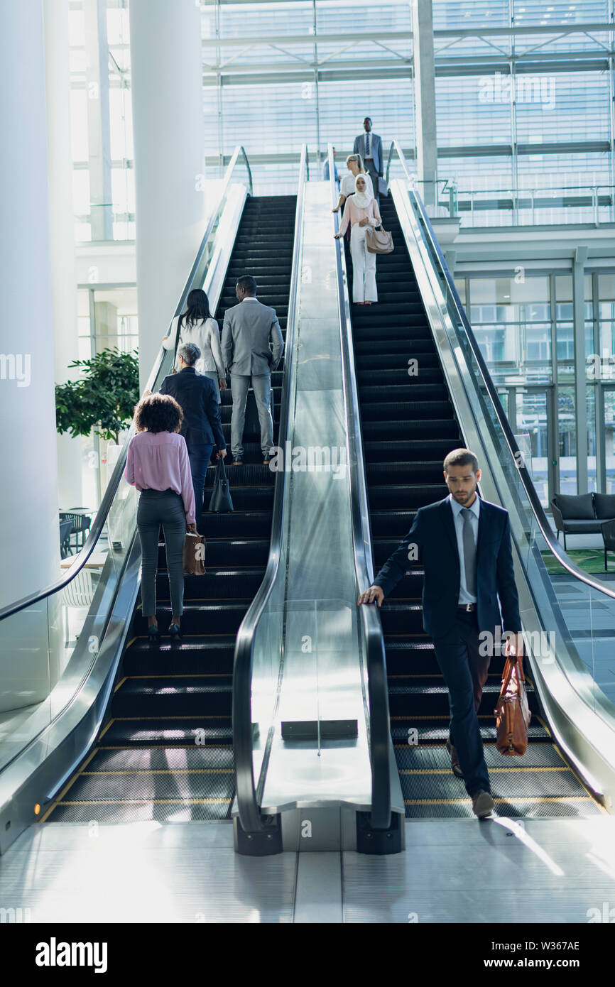 Diverse Geschäftsleute mit Fahrtreppen in modernen Büro Stockfoto