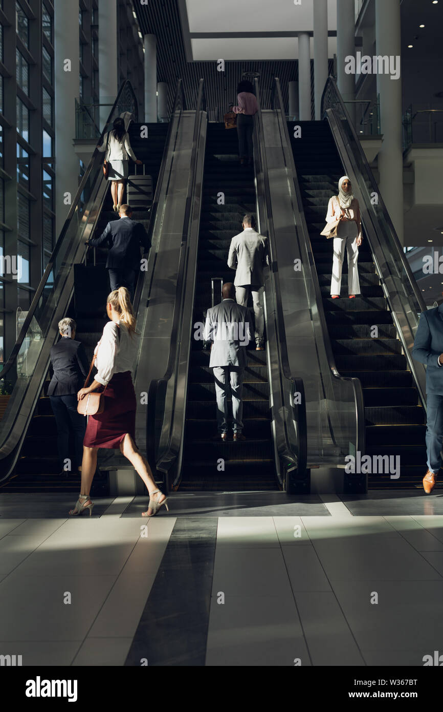Geschäftsleute mit Fahrtreppen in modernen Büro Stockfoto