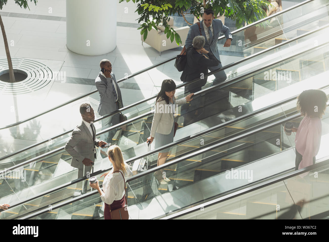 Geschäftsleute mit Fahrtreppen in modernen Büro Stockfoto