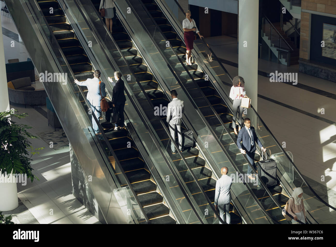 Geschäftsleute mit Fahrtreppen in modernen Büro Stockfoto