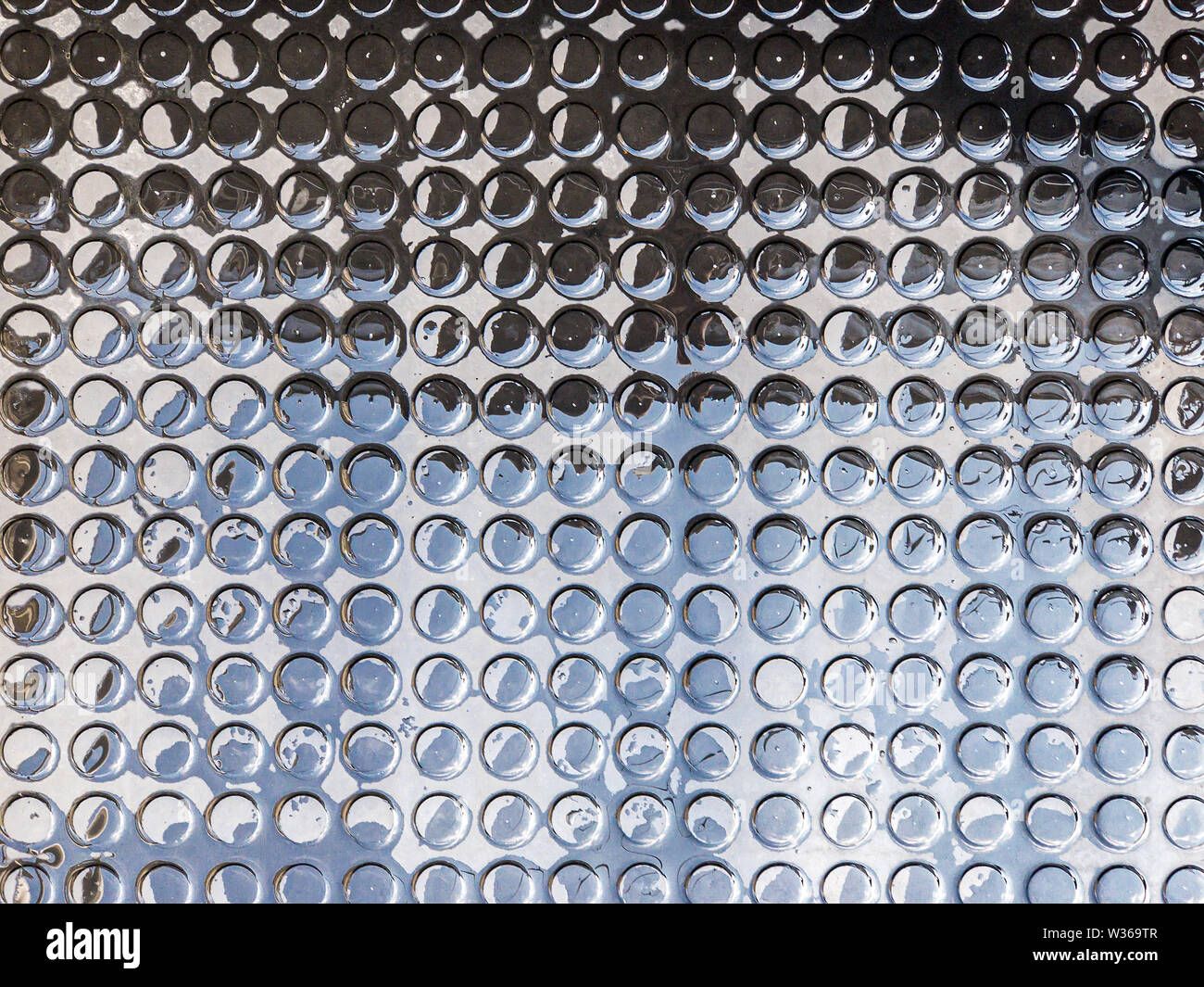 Textur Hintergrund von schwarzem Gummi Teppich mit dots Muster. Rutschfeste Gummiunterlage nach regen Stockfoto