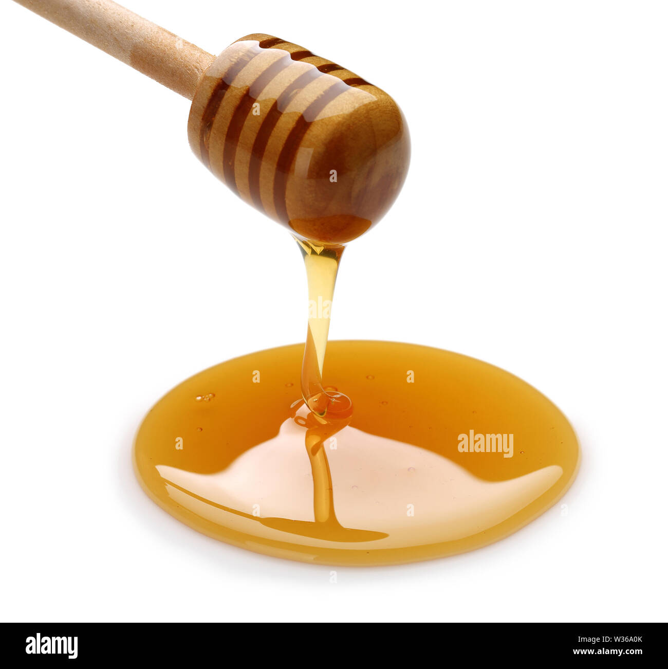 Honig tropft vom Pendelarm auf weißem Hintergrund Stockfoto