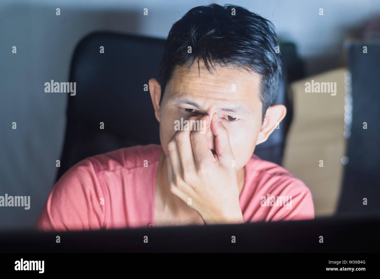 Müdigkeit Mann mit Kopfschmerzen in Büro, während Sie Computer total erschöpft spät in der Nacht. Stockfoto