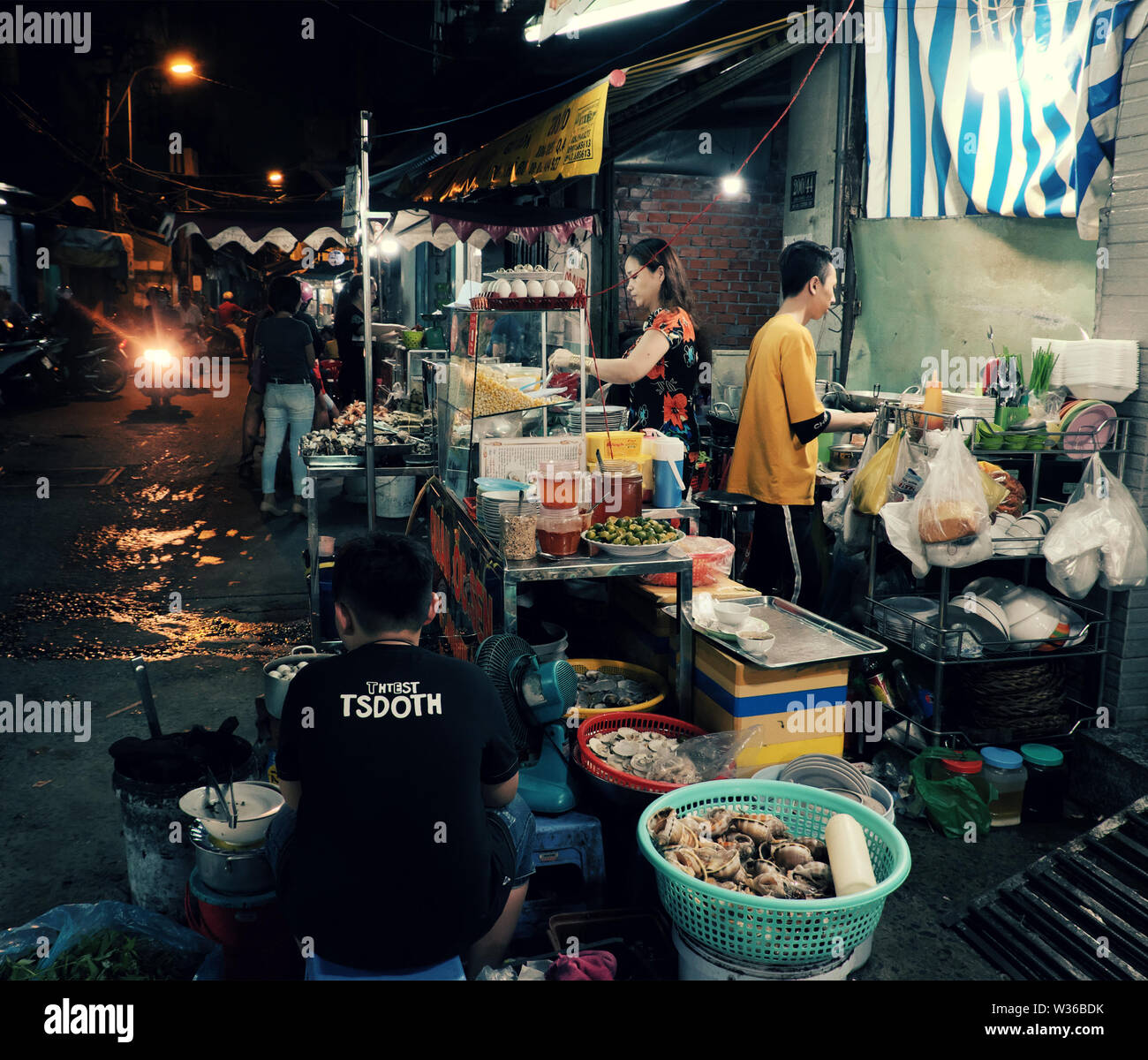 Gruppe von Diners Essen im Restaurant im Freien Nacht in Food Street, geschäftige Atmosphäre auf der Straße wenn Leute gehen in Abendessen Zeit, Vietnam Stockfoto