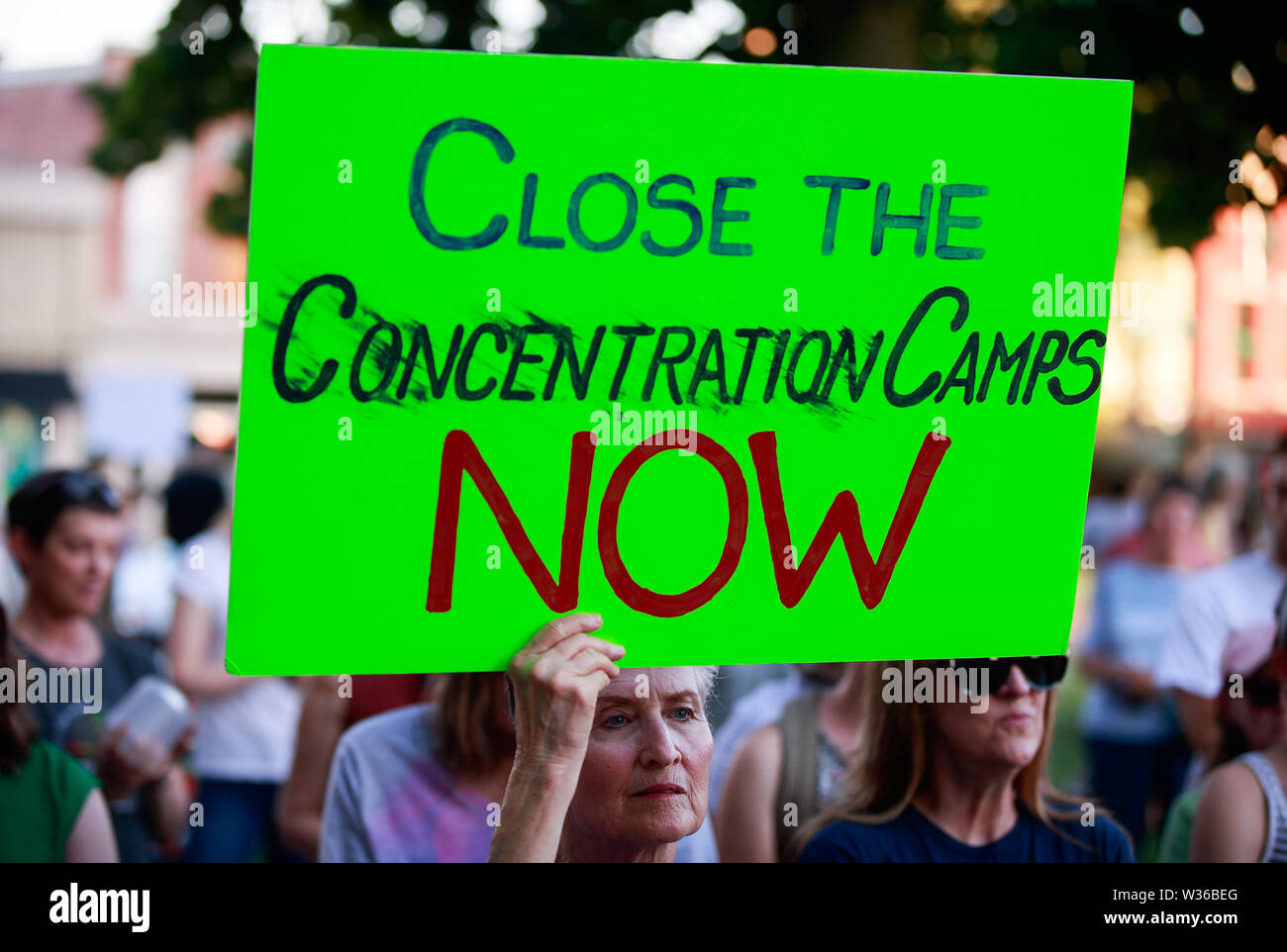 Bloomington, USA. 12. Juli, 2019. Eine Frau hält ein Schild mit der Aufschrift, "in der Nähe der Konzentrationslager", als die Demonstranten versammeln sich für die Lichter für die Freiheit: eine Mahnwache zu Ende menschlichen Internierungslagern Kundgebung und Mahnwache auf den Stufen des Monroe County Courthouse in Bloomington. USA Präsident Donald J. sagt Trumpf EIS wird Razzien gegen Immigranten ohne Papiere in amerikanischen Städten über das Wochenende durchführen. Credit: SOPA Images Limited/Alamy leben Nachrichten Stockfoto
