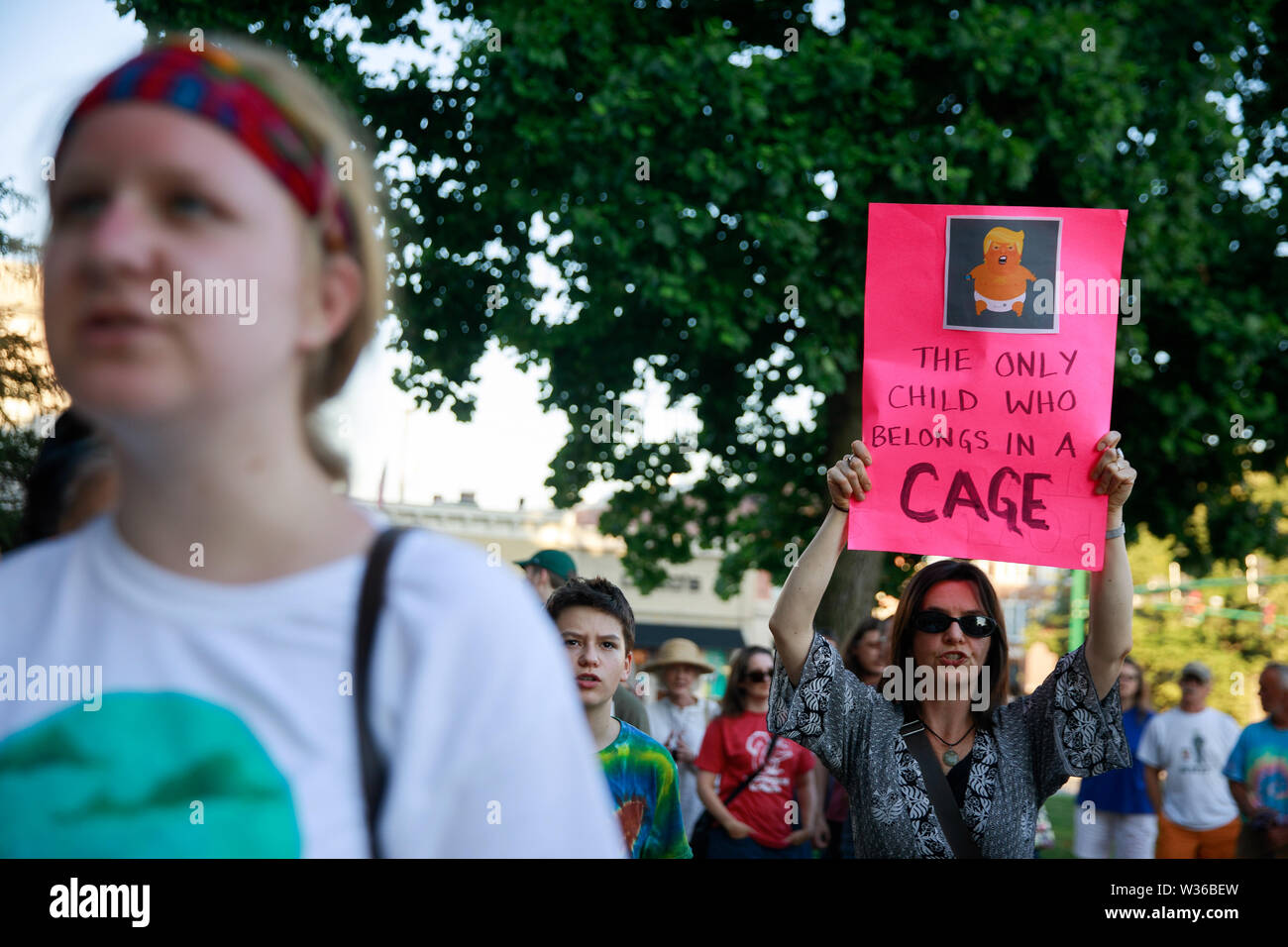 Bloomington, USA. 12. Juli, 2019. Eine Frau hält ein Schild mit einem Foto von Baby Trump, "Lesen", das einzige Kind, das gehört in ein Käfig", als die Demonstranten für die Lichter für die Freiheit: eine Mahnwache zu Ende menschlichen Internierungslagern Kundgebung und Mahnwache auf den Stufen des Monroe County Courthouse in Bloomington sammeln. USA Präsident Donald J. sagt Trumpf EIS wird Razzien gegen Immigranten ohne Papiere in amerikanischen Städten über das Wochenende durchführen. Credit: SOPA Images Limited/Alamy leben Nachrichten Stockfoto
