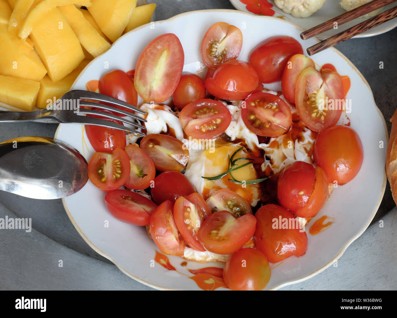 Blick von oben auf die Vietnamesische Küche Fach, nahrhafte Mahlzeit zum Mittagessen mit Brot, Tomaten, Kartoffeln, Eier, Mango, gekochtem Mais, geeignet für Fleisch, Ernährung Stockfoto