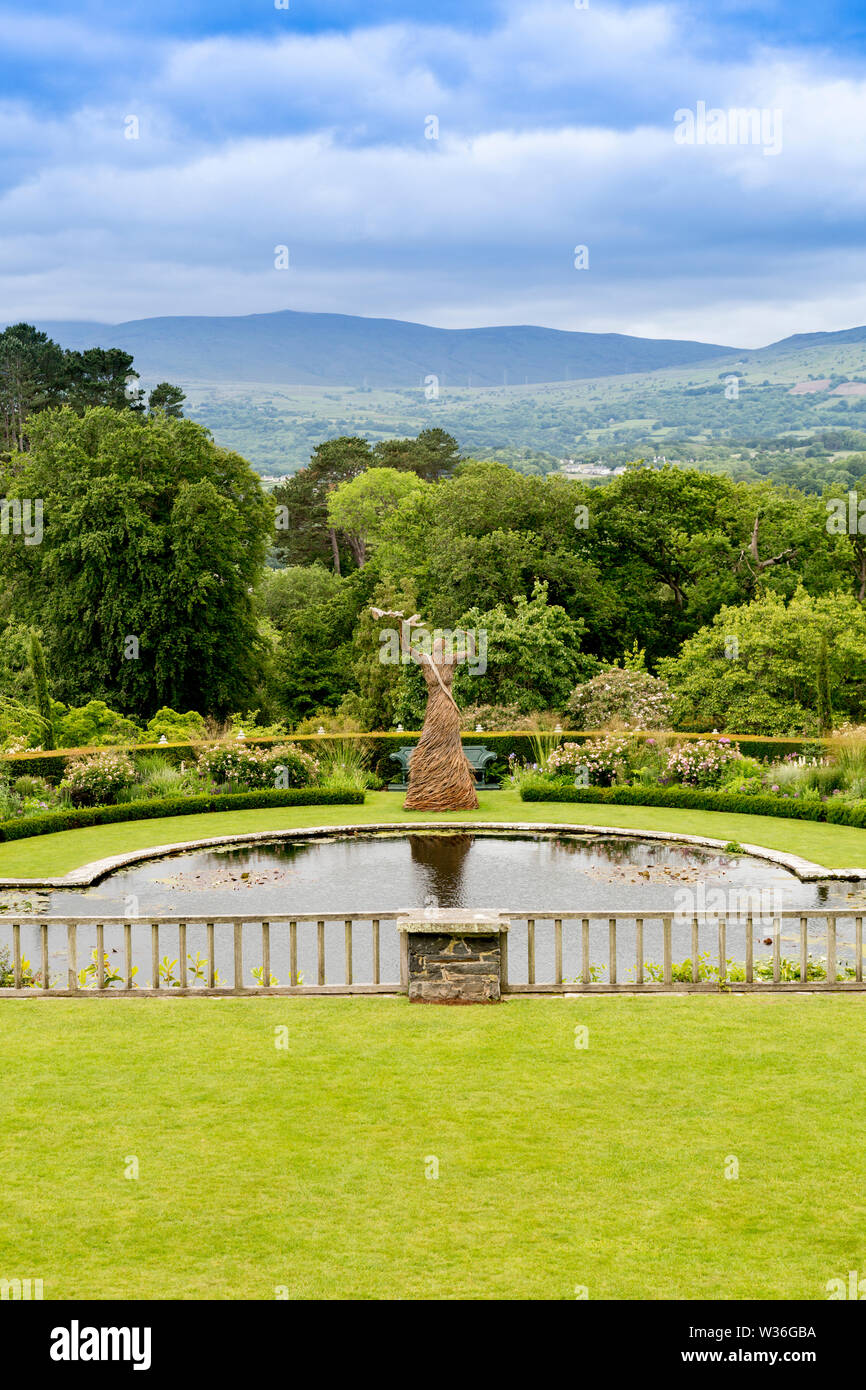 Einen 18 ft willow Frau ('Aufheben der Flügel" von Trevor Gewaehrleistung) ist eine Feier der Frauenwahlrecht auf die Lilie Terrasse in Bodnant Gardens, Conwy, Wales, Großbritannien Stockfoto